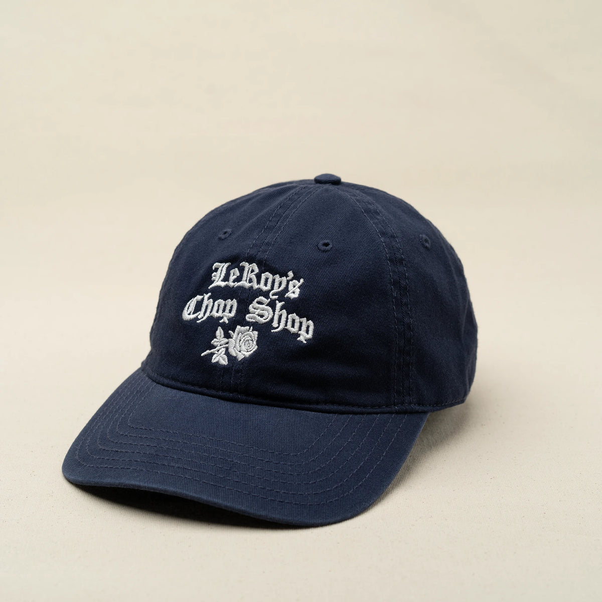 LeRoy's Chop Shop dad cap in navy with white embroidered cursive logo and rose, L'officina di LeRoy