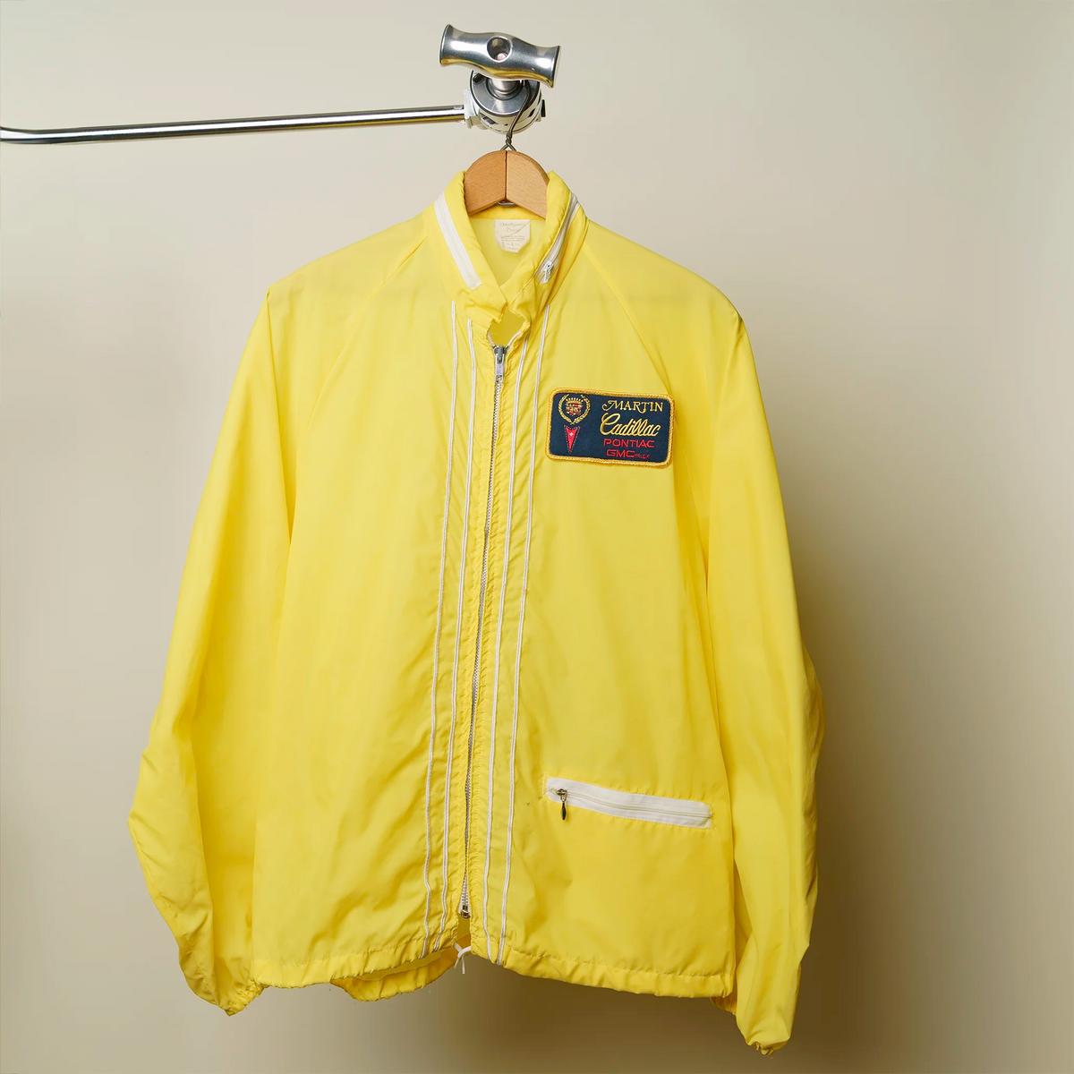 Vintage 1980s Martin Cadillac windbreaker in bright yellow with dealer patch and white stripes, large