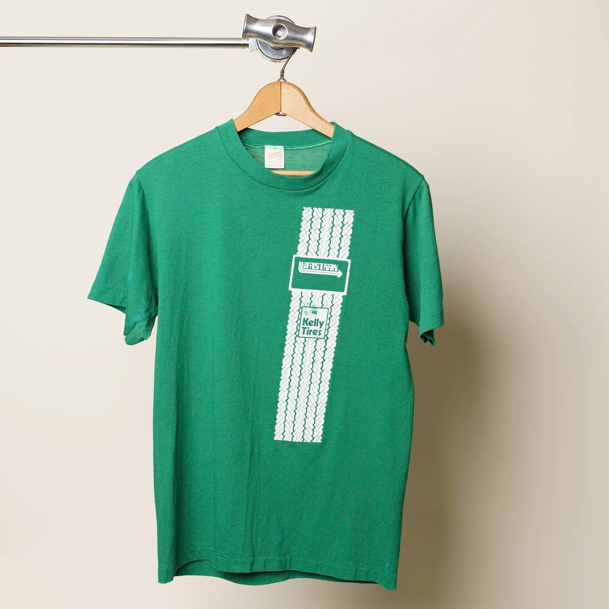 Vintage 1980s Kelly Tires tee in green with white tire tread graphic, medium