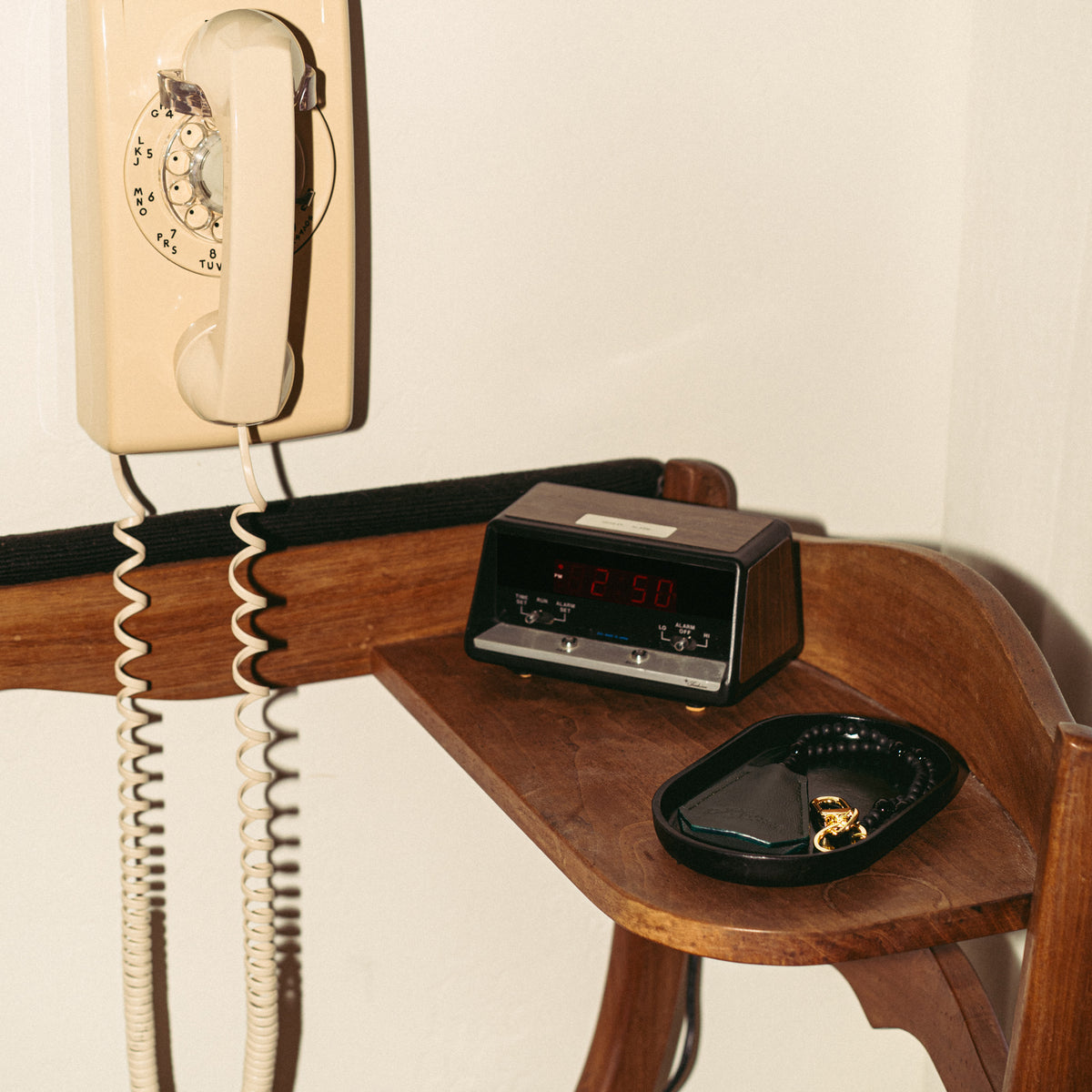 Vessel valet tray on a garage shelf next to a vintage phone and clock