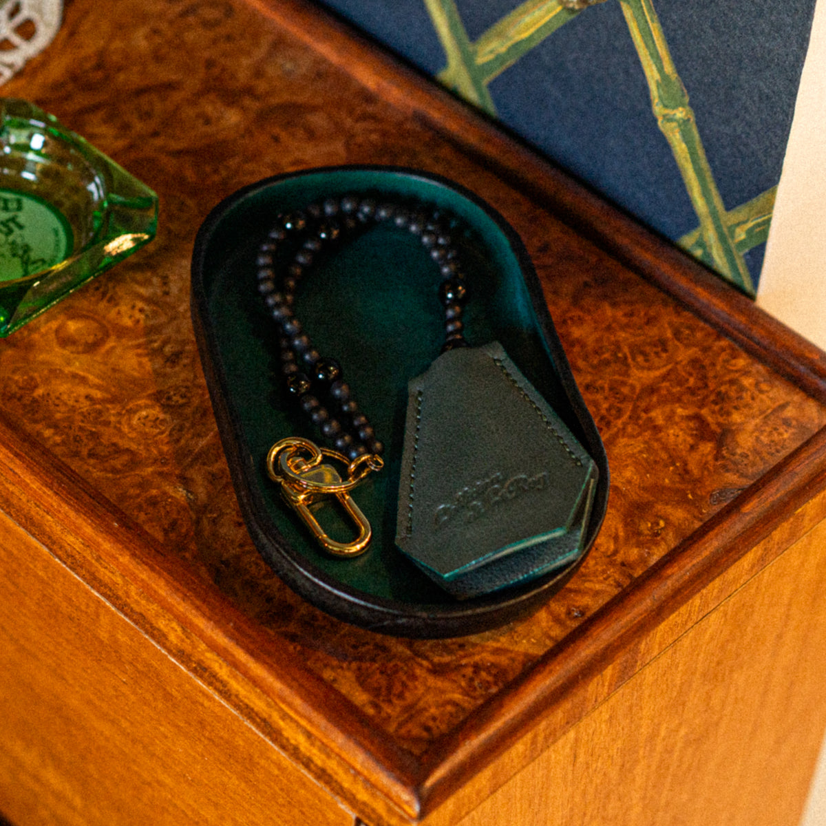 Key Coffin sitting in a Vessel leather valet tray on a wood surface