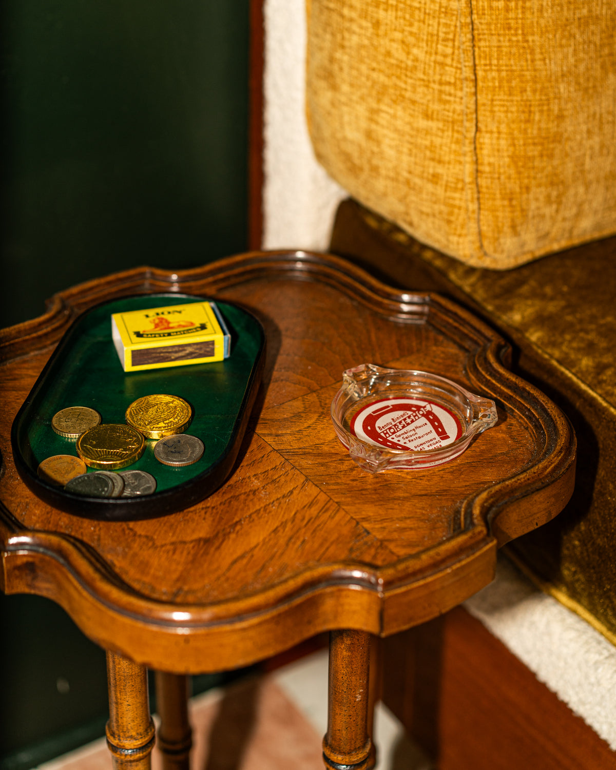 Vessel valet tray on a wood surface with coins, a box, and an ashtray