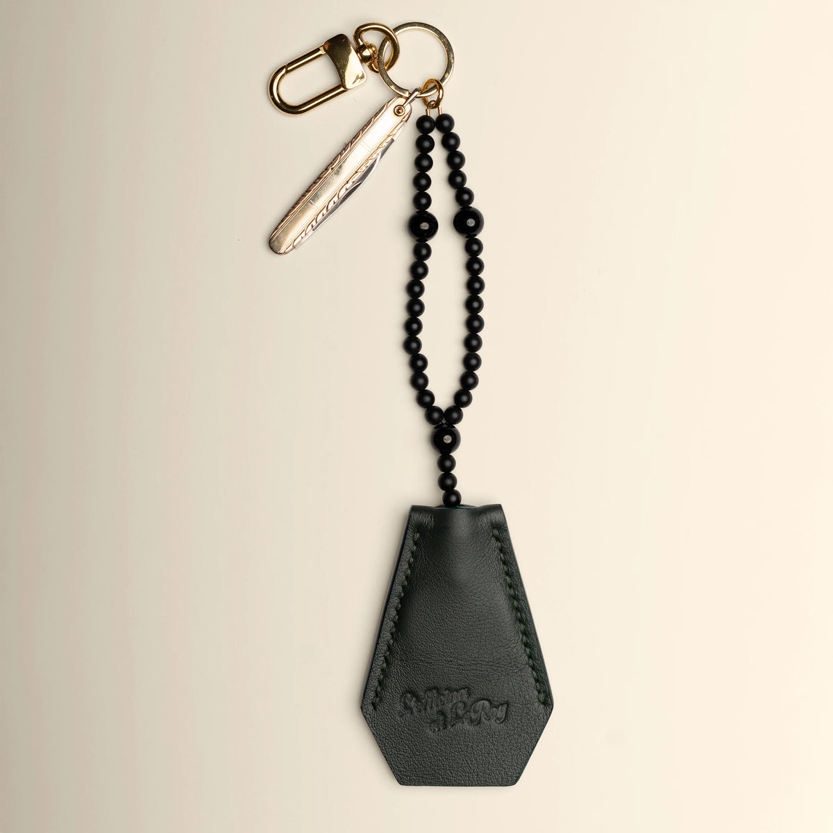Key Coffin in burgundy leather with brass ring on a beige background