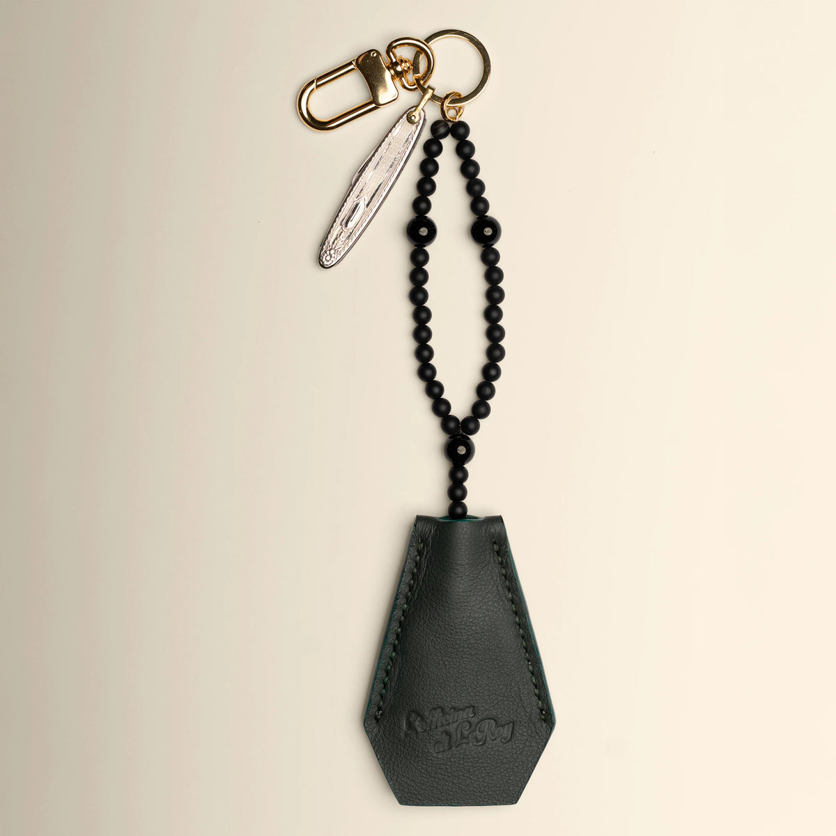 Key Coffin in navy leather with brass ring on a beige background