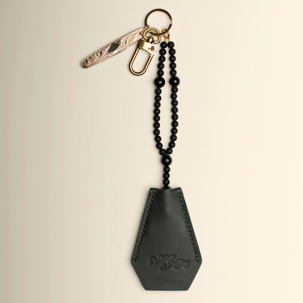 Key Coffin in brown leather with brass ring on a beige background