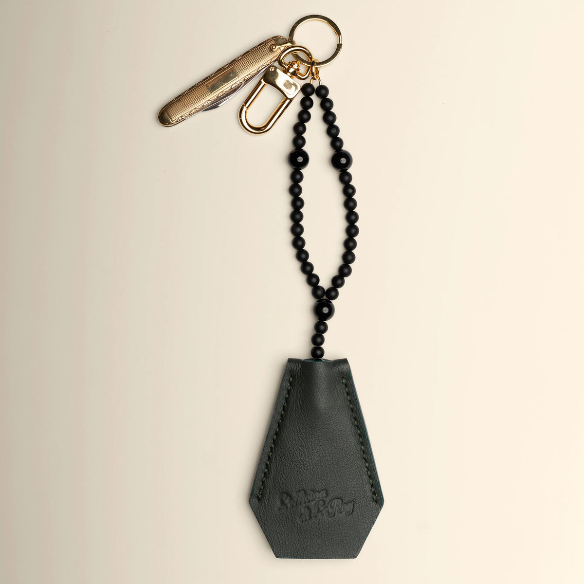 Key Coffin leather key fob angled view on a beige background