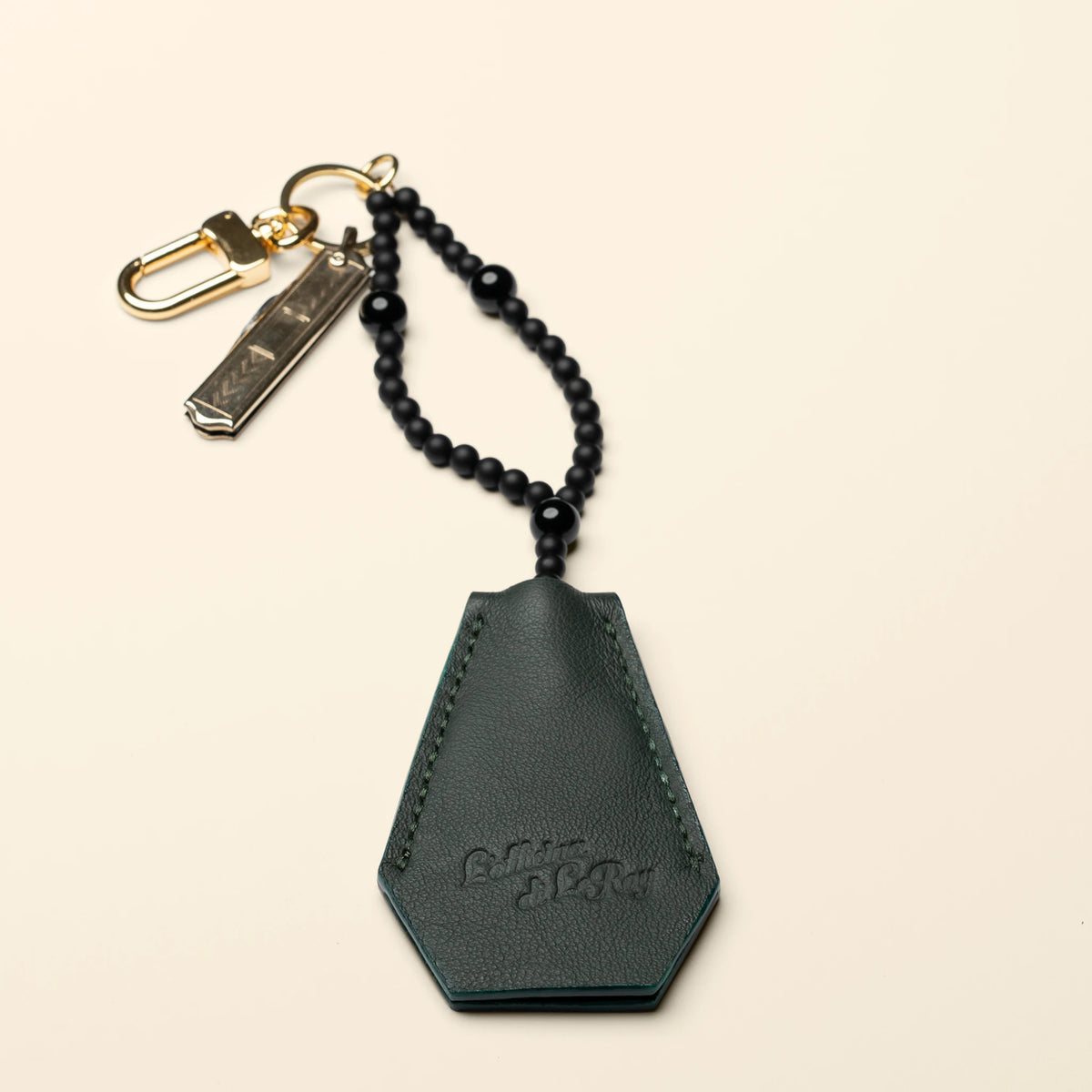 Key Coffin leather key fob, side view on a beige background