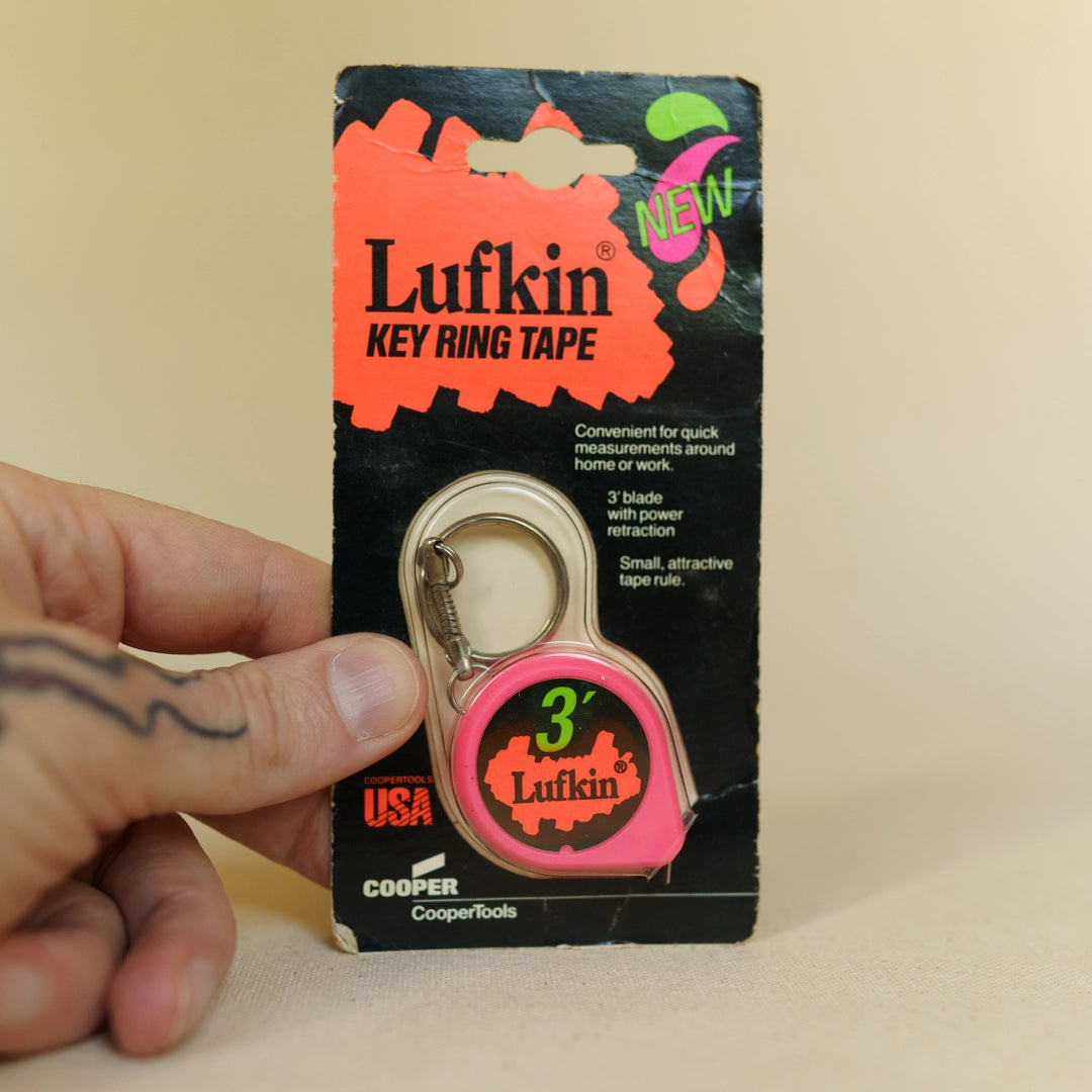 Vintage Lufkin key ring tape measure close-up showing scale markings and finish