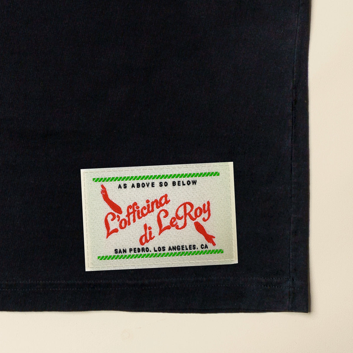 Close-up of woven ecru label detail on black heavyweight tee