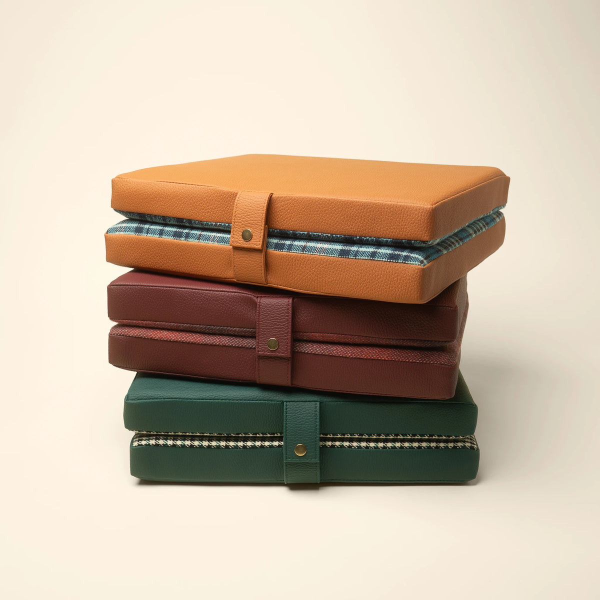 Studio Check, Tartan, and Pepita tailgate cushions grouped on a beige background