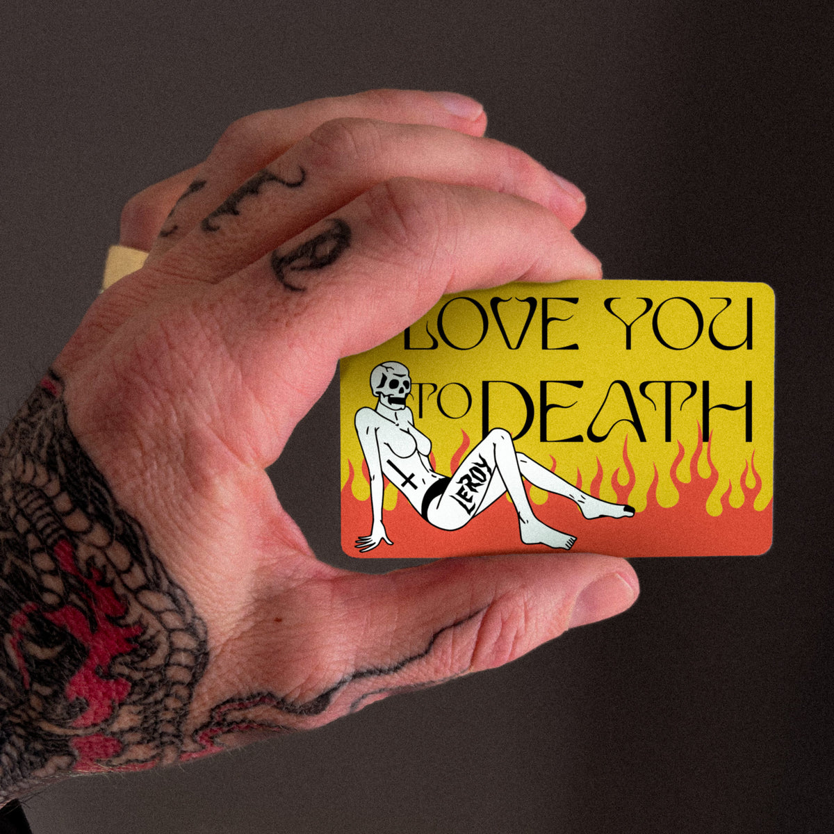 L'officina di LeRoy gift card held in a tattooed hand, reads Love You to Death